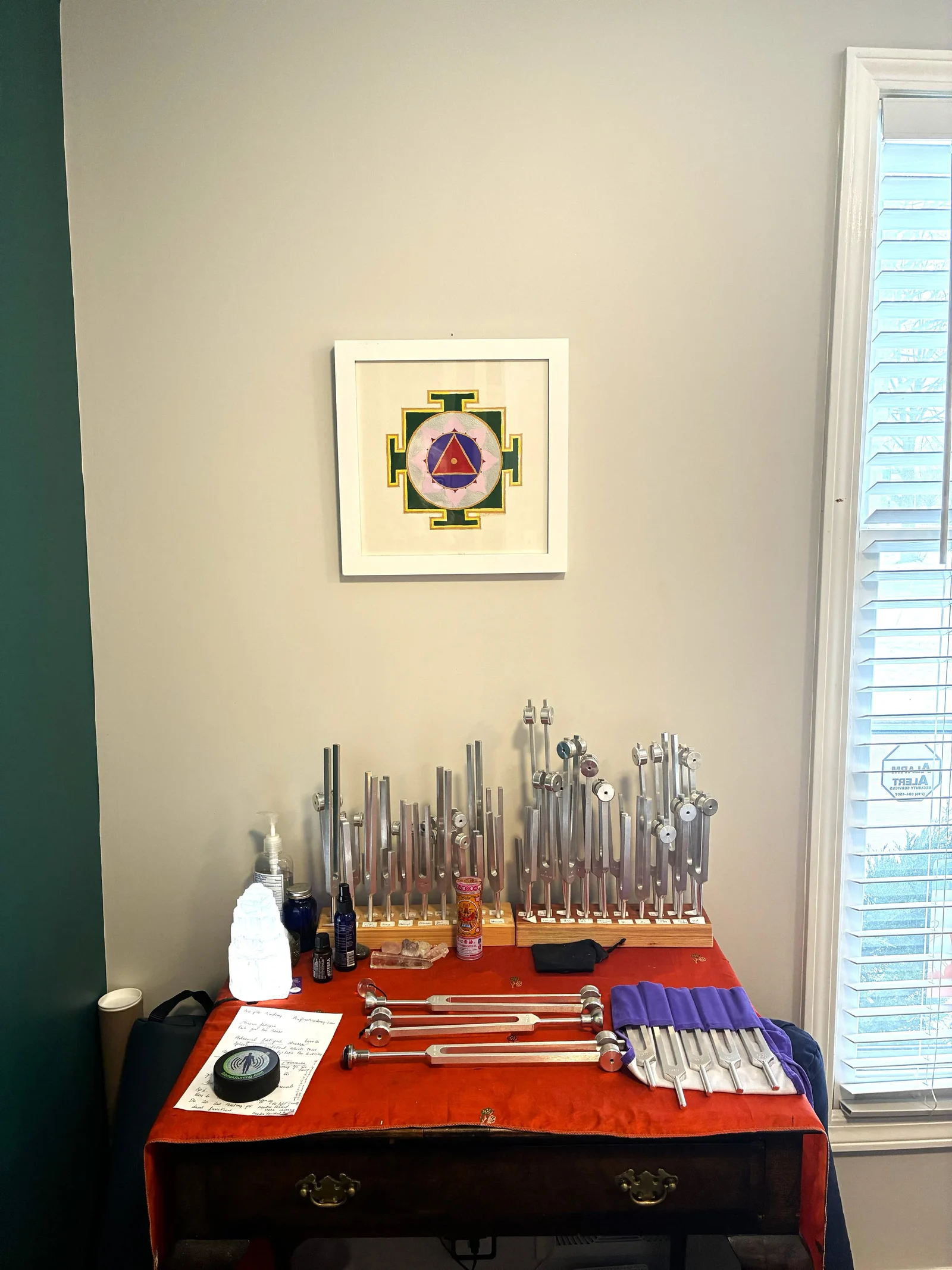 Table of tuning forks beneath a framed mandala